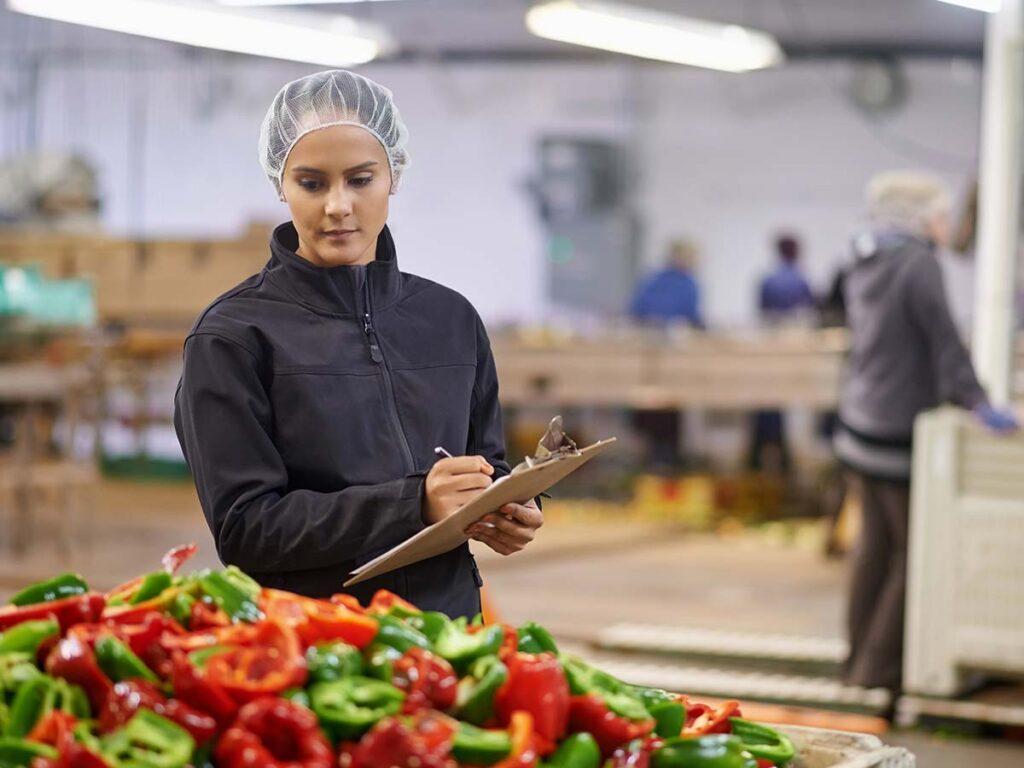 woman assessing the quality of vegetables in a wholesale environment